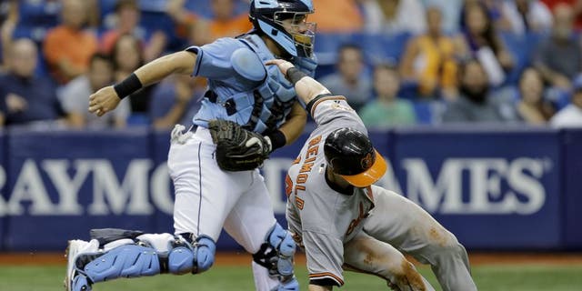 Tampa Bay Rays catcher Rene Rivera, right, tags out Baltimore Orioles' Nolan Reimold after getting caught in a rundown during the eighth inning of a baseball game Sunday, July 26, 2015, in St. Petersburg, Fla. Reimold missed the stop sign by third base coach Bobby Dickerson on a single by Jonathan Schoop off Rays pitcher Alex Colome. (AP Photo/Chris O'Meara)