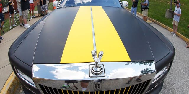 In this photo made with a fisheye lens, Pittsburgh Steelers wide receiver Antonio Brown arrives in a custom Steelers-themed Rolls Royce for NFL football training camp at the team's training facility in Latrobe, Pa., Saturday, July 25, 2015. (AP Photo/Keith Srakocic)