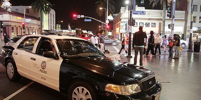 July 27: Los Angeles Police car is parked at the intersection of Hollywood Boulevard and Highland Avenue after an unruly crowd trying to attend an Electric Daisy Carnival concert film threw rocks and bottles at police cars in Los Angeles.