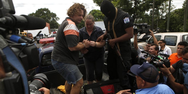 July 29: Detainees identified by Nicaraguan authorities as William Adolfo Cortez and his wife Jane Cortez prepare to walk down a police vehicle before being extradited to Panama from Nicaragua. (AP)