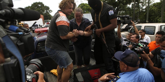 July 29: Detainees identified by Nicaraguan authorities as William Adolfo Cortez and his wife Jane Cortez prepare to walk down a police vehicle before being extradited to Panama from Nicaragua. (AP)