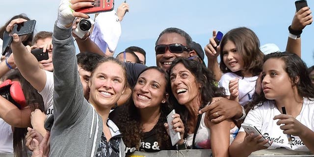 RIO DE JANEIRO, BRAZIL - JULY 29: Womens bantamweight champion Ronda Rousey of the United States takes photos with fans during open training session at Pepe Beach on July 29, 2015 in Rio de Janeiro, Brazil. (Photo by Buda Mendes/Zuffa LLC/Zuffa LLC via Getty Images)