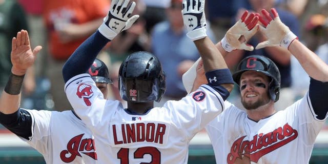 Jul 29, 2015; Cleveland, OH, USA; Cleveland Indians shortstop Francisco Lindor (12) celebrates with Indians left fielder Tyler Holt (13) and second baseman Jason Kipnis (22) after hitting a three-run home run during the sixth inning against the Kansas City Royals at Progressive Field.