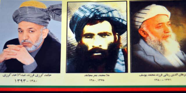 July 30, 2015: An Afghan shop clerk shows a calendar with pictures of Afghan leaders including Mullah Mohammad Omar, center, in Kandahar, south of Kabul, Afghanistan.