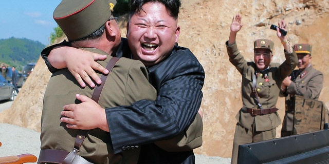 North Korean leader Kim Jong Un hugs a member of the military after a successful intercontinental ballistic missile test flight.