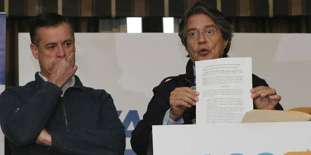 Guillermo Lasso, the opposition candidate defeated in the elections of April 2, shows a document during a press conference at Dan Carlton hotel in Quito, Ecuador, Wednesday, April 12, 2017. Lasso is demanding a recount claiming irregularities during the recent runoff presidential elections. (AP Photo/Dolores Ochoa)