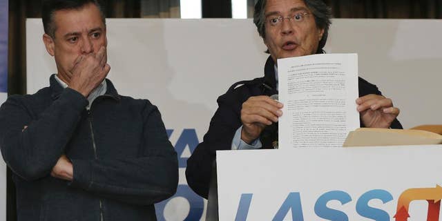 Guillermo Lasso, the opposition candidate defeated in the elections of April 2, shows a document during a press conference at Dan Carlton hotel in Quito, Ecuador, Wednesday, April 12, 2017. Lasso is demanding a recount claiming irregularities during the recent runoff presidential elections. (AP Photo/Dolores Ochoa)
