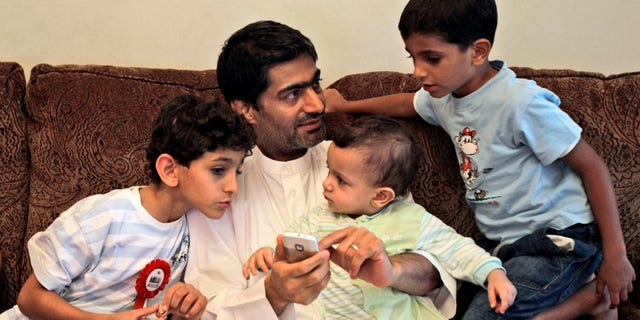FILE - In this  Tuesday, Nov. 29, 2011 file  photo, Ahmed Mansour, an Emirati blogger and a human rights activists talks with his children after he was pardoned by UAE's president and released from jail in Dubai, United Arab Emirates. In early March 2013, a total of 94 people were put on trial on charges of seeking to overthrow the UAE government and holding ties to the Muslim Brotherhood and other groups. The defendants pleaded not guilty and complained of abuses after their arrests. Mansour and four others including a former legal adviser to the UAE's armed forces were among the first to face arrests for alleged anti-state crimes in early 2011 after signing an online petition urging for political reforms, including free elections for parliament. (AP Photo/Kamran Jebreili, File)