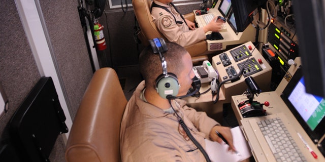 Capt. Ryan Jodoi, a UAV pilot, flies an MQ-9 Reaper while Airman 1st Class Patrick Snyder controls a full motion video camera at Kandahar Air Base, Afghanistan, March 13, 2009, in support of Operation Enduring Freedom. (U.S. Air Force photo by Staff Sgt. James L. Harper Jr.)