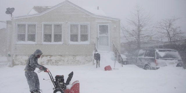 Gilberto Colin gets a head start on snowplowing his property during the middle of a snowstorm, Thursday, Jan. 4, 2018, in Neptune, N.J