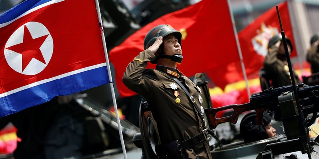 A soldier salutes from atop an armored vehicle as it drives past the stand with North Korean leader Kim Jong Un during a military parade marking the 105th birth anniversary of country's founding father Kim Il Sung.