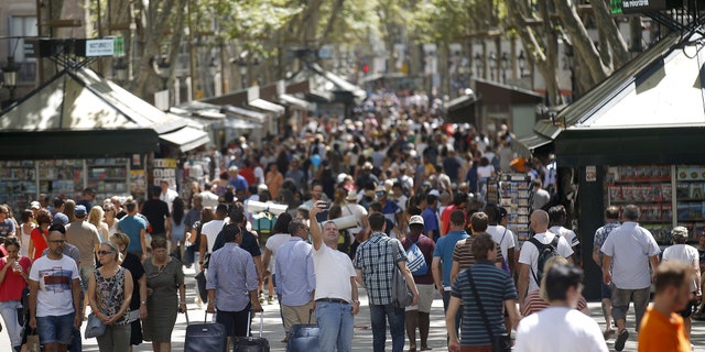 A man takes a selfie at Las Ramblas in Barcelona, Spain, August 16, 2015. Barcelona's new mayor is picking a fight with home rental websites as she tries to crack down on uncontrolled tourism that she fears could drive out poor residents and spoil the Catalan capital's charm. Picture taken on August 16, 2015. REUTERS/Albert Gea - RTX1PQRT