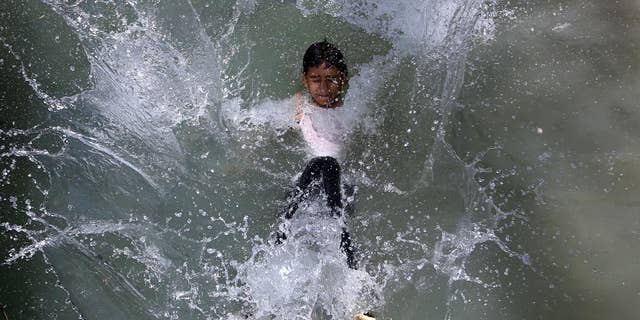 An Afghan teenager jumps into a canal on the outskirts of Kabul, Afghanistan on Wednesday, July 13, 2016. (AP Photo/Rahmat Gul)
