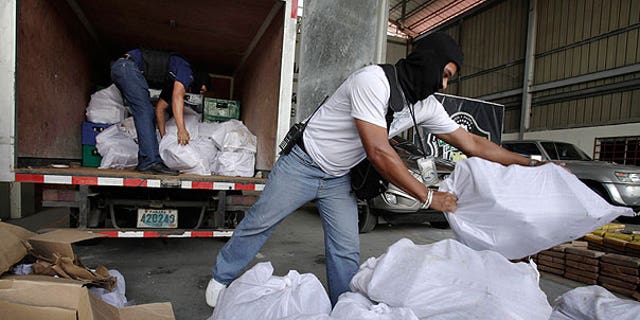 Aug. 1: Anti-narcotic agents unload sacks containing packages of heroin during a press conference in Panama City.