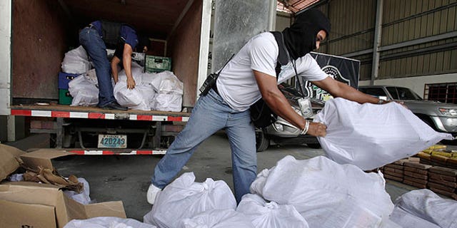 Aug. 1: Anti-narcotic agents unload sacks containing packages of heroin during a press conference in Panama City.
