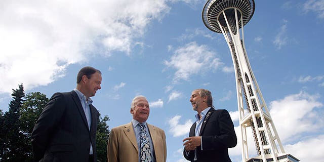 July 31: Buzz Aldrin, former astronaut (center), and Richard Garriott, first second-generation space traveler (right), talk about space exploration outside the Space Needle in Seattle as Ron Sevart, CEO of the Space Needle, listens in.
