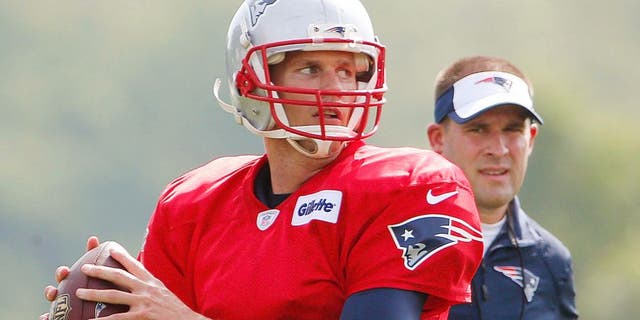 Jul 30, 2015; Foxborough, MA, USA; As offensive coordinator Josh McDaniels looks on, New England Patriots quarterback Tom Brady (12) throws during training camp at Gillette Stadium. Mandatory Credit: Winslow Townson-USA TODAY Sports