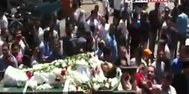 Aug. 2: In this image made from amateur video released by Ugarit News and accessed via The Associated Press Television News, mourners carry the body of a man during a funeral ceremony in the city of Homs, Syria. After killing scores of people in two days, Syrian troops tightened their siege on the city of Hama Tuesday by taking up positions near homes and sending residents fleeing for their lives.