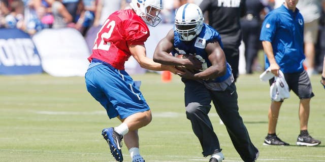 Aug 2, 2015; Anderson, IN, USA; Indianapolis Colts quarterback Andrew Luck (12) hands the ball off to running back Frank Gore (23) during training camp at Anderson University. Mandatory Credit: Brian Spurlock-USA TODAY Sports