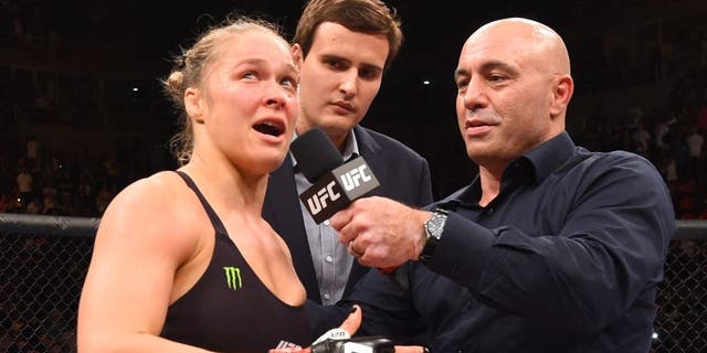 RIO DE JANEIRO, BRAZIL - AUGUST 01: (L-R) Ronda Rousey of the United States speaks to Joe Rogan after her knock out victory over Bethe Correia of Brazil in the first round in their UFC women's bantamweight championship bout during the UFC 190 event inside HSBC Arena on August 1, 2015 in Rio de Janeiro, Brazil. (Photo by Josh Hedges/Zuffa LLC/Zuffa LLC via Getty Images)