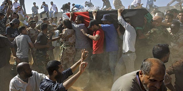 July 29: Libyan men carry a coffin, gesture and chant slogans during funeral of Libyan rebels' military chief Abdel-Fattah Younis in the rebel-held town of Benghazi, Libya.