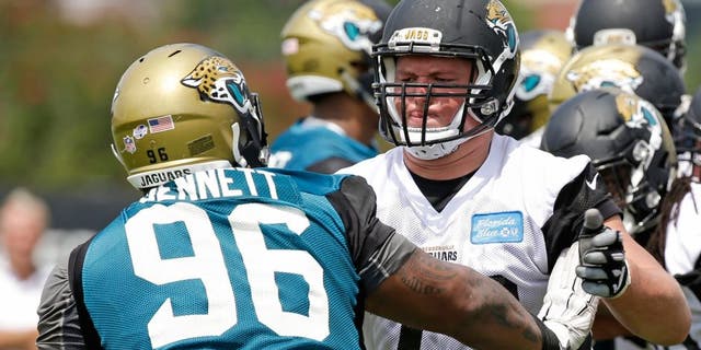Jacksonville Jaguars tackle Josh Wells (72) blocks defensive tackle Michael Bennett (96) during a light scrimmage at NFL football training camp, Friday, July 31, 2015, in Jacksonville, Fla. (AP Photo/John Raoux)