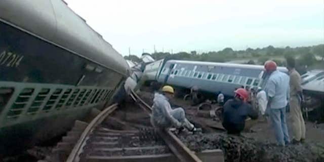 Aug. 5, 2015: In this image made from video, people gather by the twisted track alongside two derailed trains in Harda in Madhya Pradesh state, India.