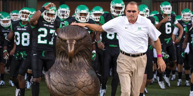 Oct 31, 2013; Denton, TX, USA; North Texas Mean Green head coach Dan McCarney leads his team on the field to face the Rice Owls at Apogee Stadium. The Mean Green defeated the Owls 28-16. Mandatory Credit: Jerome Miron-USA TODAY Sports