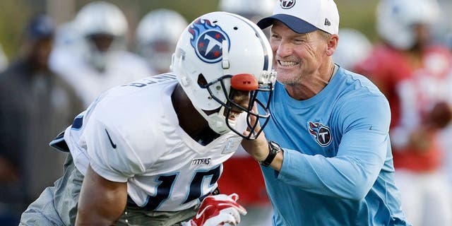 Tennessee Titans head coach Ken Whisenhunt, right, defends against wide receiver Justin Hunter (15) during NFL football training camp Monday, Aug. 3, 2015, in Nashville, Tenn. (AP Photo/Mark Humphrey)