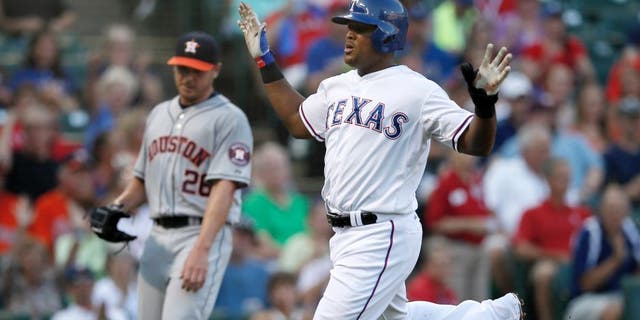Texas Rangers' Adrian Beltre celebrates after crossing the plate, scoring on a Elvis Andrus single off of Houston Astros' Scott Kazmir, rear, in the first inning of a baseball game, Wednesday Aug. 5, 2015, in Arlington, Texas. (AP Photo/Tony Gutierrez)