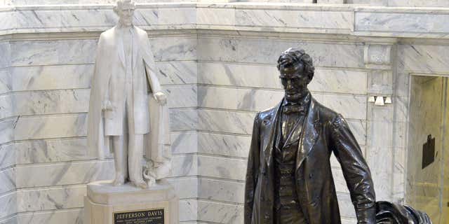 Aug. 5, 2015: The statue of Jefferson Davis, left, overlooks the statue of Abraham Lincoln in the Rotunda of the Kentucky State Capitol in Frankfort Ky.