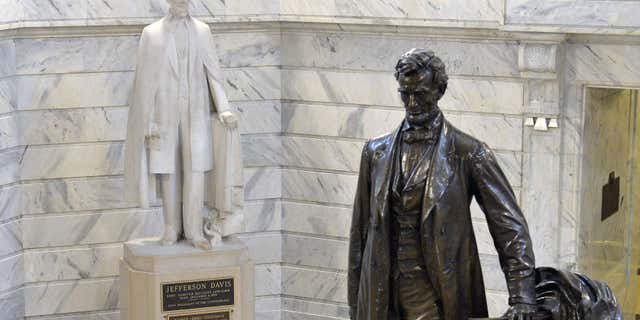 Aug. 5, 2015: The statue of Jefferson Davis, left, overlooks the statue of Abraham Lincoln in the Rotunda of the Kentucky State Capitol in Frankfort Ky.