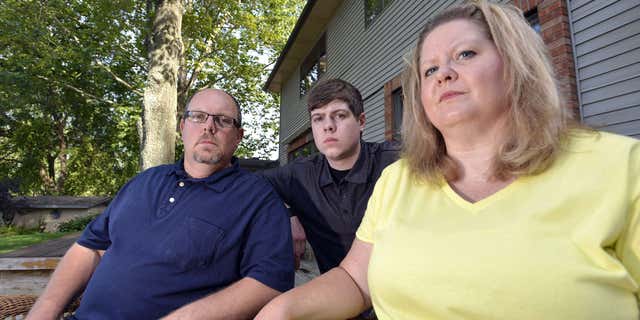 July 22, 2015: Zach Anderson, center, and his parents, Les and Amanda Anderson, pose for a photo at their home in Elkhart, Ind. Zach and his parents are embroiled in a legal battle with a Niles, Mich.