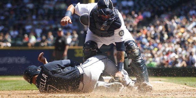 Aug 6, 2014; Seattle, WA, USA; Seattle Mariners catcher Jesus Sucre (2) blocks Atlanta Braves second baseman Tommy La Stella (7) from scoring a run during the third inning at Safeco Field. Mandatory Credit: Joe Nicholson-USA TODAY Sports