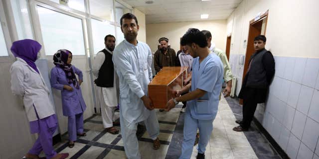 Aug. 7, 2015: Hospital workers carry the dead body of a victim in a car bomb attack in Kabul, Afghanistan.