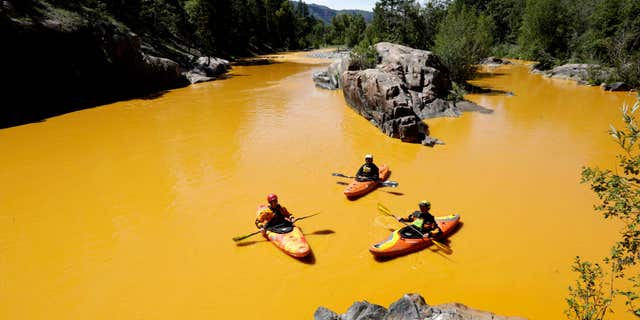 Aug. 6, 2015: People kayak in the Animas River near Durango, Colo. in water colored from a mine waste spill.