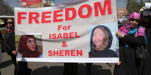 March 5, 2015: Yemeni activists hold a banner with pictures of kidnapped French Isabelle Prime, right, and her Yemeni colleague during a protest in Sanaa, Yemen.