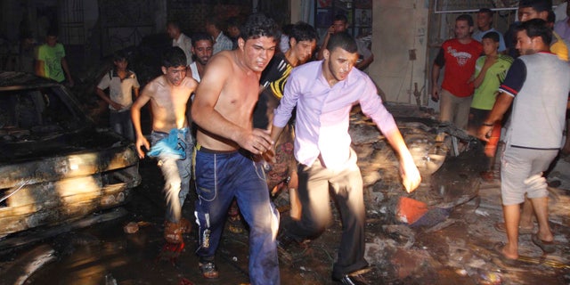 Aug. 7: Iraqi men evacuate a victim from the scene of an explosion in Basra, Iraq's second-largest city, 340 miles southeast of Baghdad, Iraq.