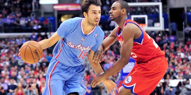 February 9, 2014; Los Angeles, CA, USA; Los Angeles Clippers shooting guard Sasha Vujacic (18) moves the ball against Philadelphia 76ers shooting guard Elliot Williams (25) during the second half at Staples Center. Mandatory Credit: Gary A. Vasquez-USA TODAY Sports