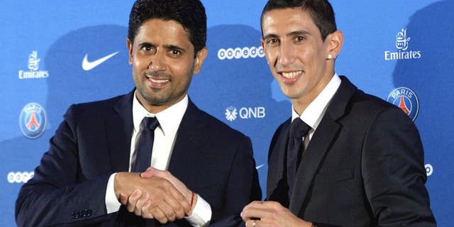 Paris Saint-Germain's (PSG) new Argentinian midfielder Angel Di Maria (R) and Paris Saint-Germain's Qatari president Nasser Al-Khelaifi (L) pose with Di Maria's PSG jersey during an official presentation in Paris on August 6, 2015. Paris Saint-Germain completed the signing of Di Maria from Manchester United on a four-year deal, the French champions announced. AFP PHOTO / MIGUEL MEDINA (Photo credit should read MIGUEL MEDINA/AFP/Getty Images)