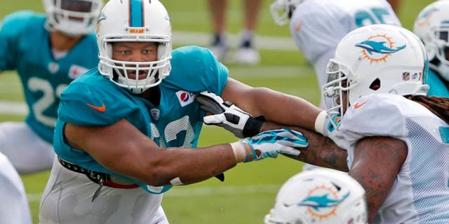 Miami Dolphins defensive tackle Ndamukong Suh (93) runs drills during NFL training camp, Saturday, Aug. 1, 2015 at Nova Southeastern University in Davie, Fla. (Al Diaz/The Miami Herald via AP) MAGS OUT; MANDATORY CREDIT