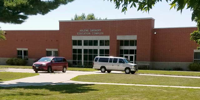 In this photo provided by the State of Iowa, vehicles are parked out the entrance to the Arlene Dayhoff Education Complex at the Boys State Training School in Eldora, Iowa, Monday, Aug. 7, 2017.