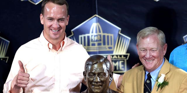 Aug 8, 2015, Canton, OH, USA; Denver Broncos quarterback Peyton Manning (left) and Bill Polian pose with the bust at the 2015 Pro Football Enshrinement Cermony at Tom Benson Hall of Fame Stadium. Mandatory Credit: Andrew Weber-USA TODAY Sports