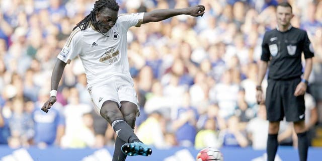 Swansea City's French striker Bafetimbi Gomis scores a second equalising goal from the penalty spot for 2-2 during the English Premier League football match between Chelsea and Swansea City at Stamford Bridge in London on August 8, 2015. AFP PHOTO / ADRIAN DENNIS RESTRICTED TO EDITORIAL USE. No use with unauthorized audio, video, data, fixture lists, club/league logos or 'live' services. Online in-match use limited to 75 images, no video emulation. No use in betting, games or single club/league/player publications. (Photo credit should read ADRIAN DENNIS/AFP/Getty Images)