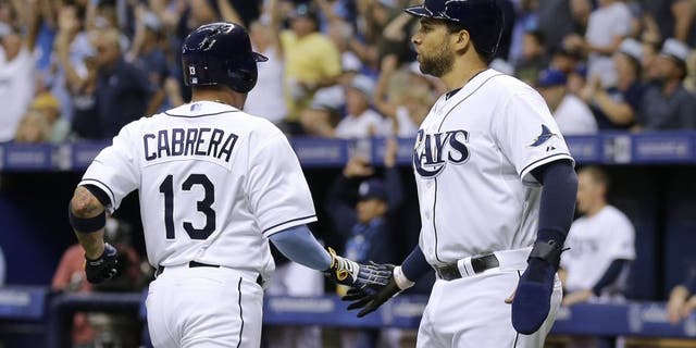 Tampa Bay Rays' James Loney and Asdrubal Cabrera (13) celebrate after scoring on a two-run single by Kevin Kiermaier off New York Mets starting pitcher Noah Syndergaard during the first inning of an interleague baseball game Saturday, Aug. 8, 2015, in St. Petersburg, Fla. (AP Photo/Chris O'Meara)