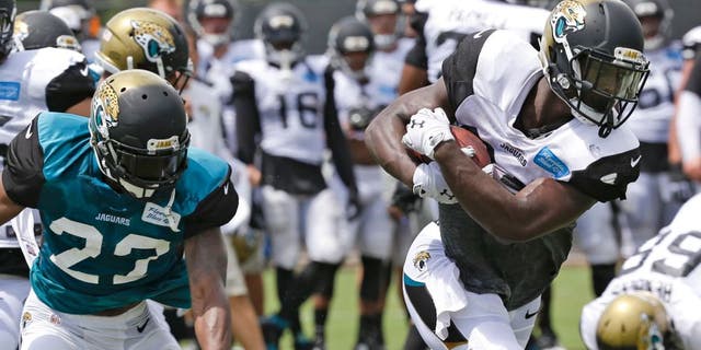 Jacksonville Jaguars running back T.J. Yeldon, front right, gets past cornerback Jeremy Harris (23) during practice at NFL football training camp, Wednesday, Aug. 5, 2015, in Jacksonville, Fla. (AP Photo/John Raoux)