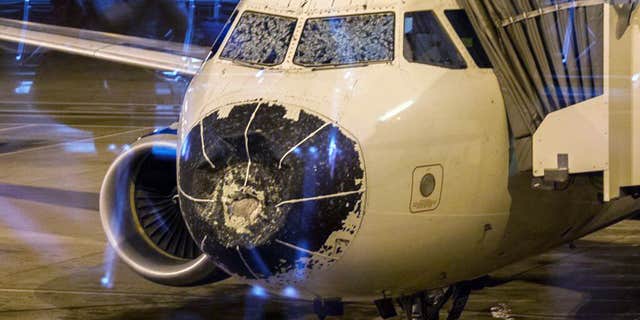 Aug. 7, 2015: This photo provided by Beau Sorensen shows the damage done by hail to the nose cone and windshield of a Delta flight.