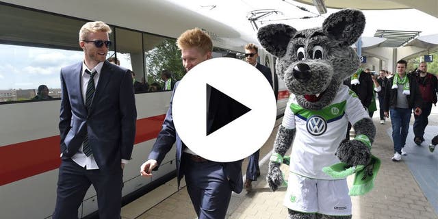 Wolfsburg's striker Andre Schuerrle (L) walks with Wolfsburg's Belgian midfielder Kevin De Bruyne and Wolfsburg's mascot on arrival at the main station in Wolfsburg, central Germany on May 31, 2015, after the German Cup DFB Pokal final football match between BVB Borussia Dortmund and VfL Wolfsburg on May 30 in Berlin. Wolfsburg won the match 1-3. AFP PHOTO / TOBIAS SCHWARZ (Photo credit should read TOBIAS SCHWARZ/AFP/Getty Images)