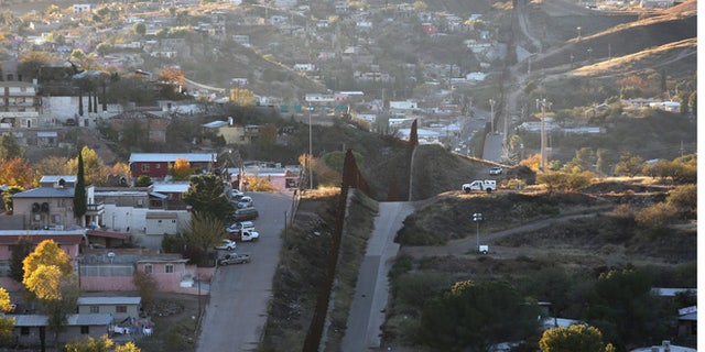 NOGALES, AZ - DECEMBER 09: A U.S. Border Patrol agent watches over the U.S.-Mexico border fence from his vehicle on December 9, 2014 in Nogales, Arizona. With increased manpower and funding in recent years, the Border Patol has seen the number illegal crossings and apprehensions of undocumented immigrants decrease in the Tucson sector. Agents are waiting to see if the improved U.S. economy and housing construction will again draw more immigrants from the south. (Photo by John Moore/Getty Images)