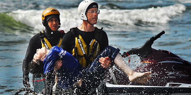 August 5: Surf rescue swimmer Doug Knutzen carries Dale Ostrander to the shore of the Cranberry Rd. beach approach in Long Beach, Wash.  Rescue swimmers Eddie Mendez, left, and Will Green found Ostrander in the surf.